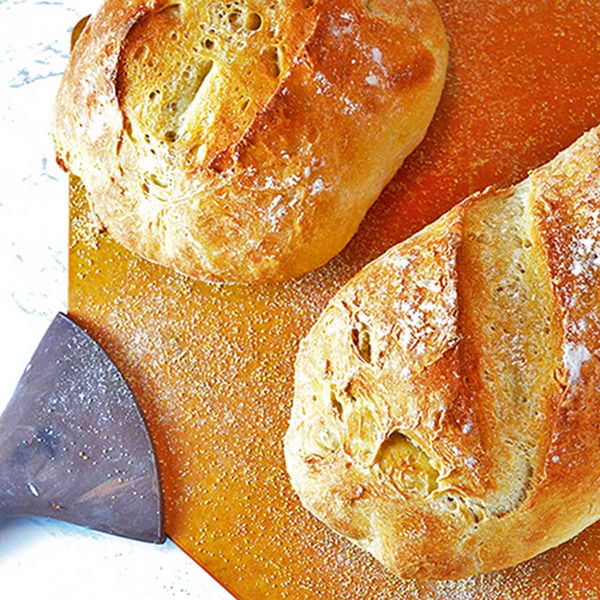 2 loaves of homemade bread on a pizza peel.