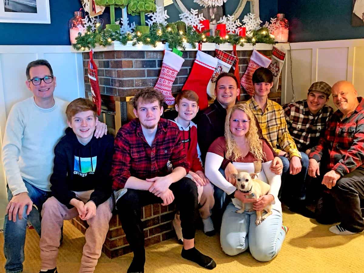 A family photo in front of a fireplace.