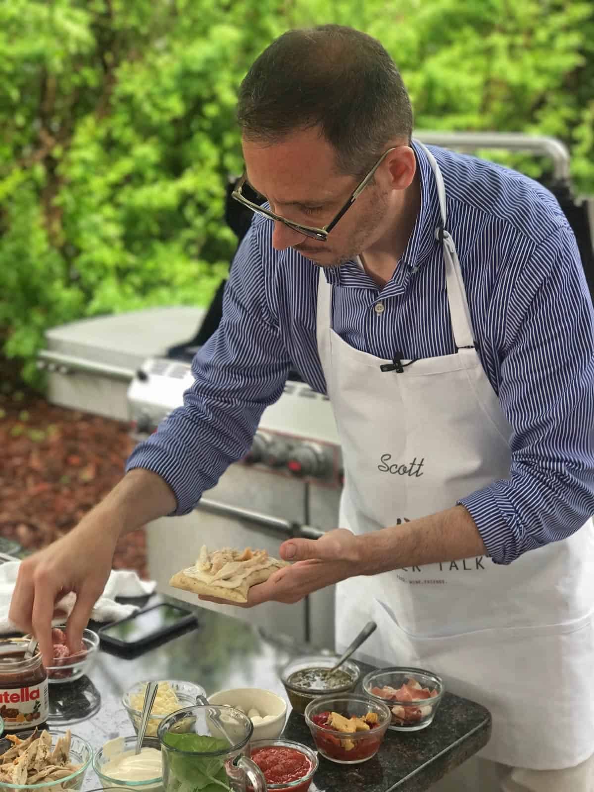 A man making some grilled pizza.